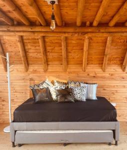 Bett in einem Zimmer mit Holzwänden in der Unterkunft ThanSam Cabaña in San Vicente