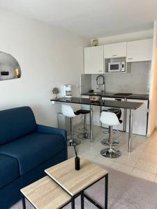 坎城的住宿－Appartement 2 pièces de 29 m2，一间带蓝色沙发的客厅和一间厨房