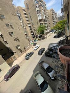 a group of cars parked on a street with buildings at Adam Abbas Al Akkad Hotel in Cairo