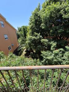 a wooden railing in front of a building with trees at Guest House Damjana in Budva