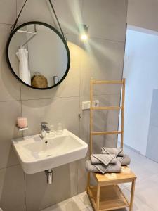 ein Bad mit einem Waschbecken und einem Spiegel in der Unterkunft Hotel-Bistro-Europa in Merchweiler