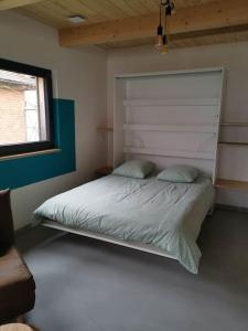 a bedroom with a bed with a large headboard at Studio cocooning Betschdorf in Oberbetschdorf