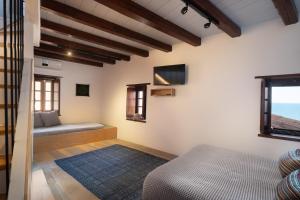 um quarto com uma cama e uma televisão na parede em Kalnterimi Guesthouses em Monemvasia