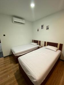 a room with two beds and a heater at Hotel Berlian in Pontianak
