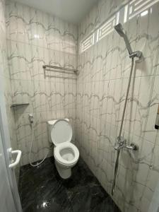 a bathroom with a toilet and a shower in it at Hotel Berlian in Pontianak
