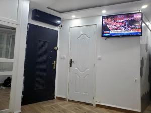 Zimmer mit einer weißen Tür und einem TV an der Wand in der Unterkunft la perle de bougie in Bejaïa