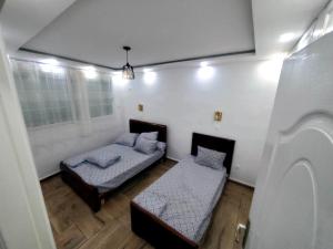 a bedroom with two beds and a window at la perle de bougie in Bejaïa