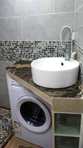 a bathroom with a sink and a washing machine at la perle de bougie in Bejaïa +3 photos