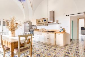 una cucina con tavolo e sedie in una stanza di Antica Villa del Conte a Porto Cesareo