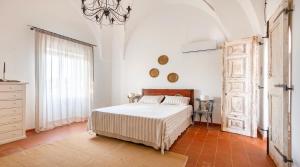 Habitación blanca con cama y ventana en Antica Villa del Conte, en Porto Cesareo