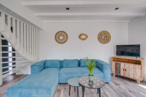 ein Wohnzimmer mit einem blauen Sofa und einem Tisch in der Unterkunft LA VILLA KUDETA - Belle maison avec piscine in Bouliac