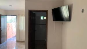 a flat screen tv on a wall next to a door at posada cándita in Tizimín