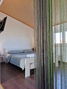 1 dormitorio con cama y ventana grande en Apartmani Vana 1, en Tribunj