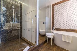 a bathroom with a tub and a shower and a toilet at Hotel Santa Marta in Lloret de Mar