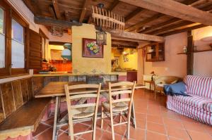 a kitchen and living room with a table and chairs at Galliner, El Reixac Casa Rural in Sant Joan de les Abadesses