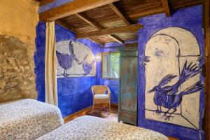 a bedroom with a painting of a peacock on the wall at Galliner, El Reixac Casa Rural in Sant Joan de les Abadesses