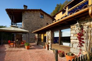 een gebouw met een patio met een tafel en stoelen bij Galliner, El Reixac Casa Rural in Sant Joan de les Abadesses