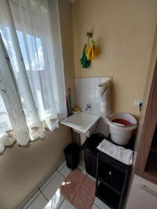 uma casa de banho com um WC, um lavatório e uma janela em Apartamento inteiro com garagem coberta em União da Vitória