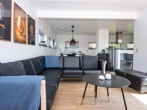 Knebelにある8 person holiday home in Knebelのリビングルーム(黒いソファ、テーブル付)