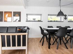 Knebelにある8 person holiday home in Knebelのダイニングルーム(黒いテーブルと椅子付)
