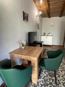 uma mesa de madeira e duas cadeiras verdes num quarto em Private em Shchūchīnsk
