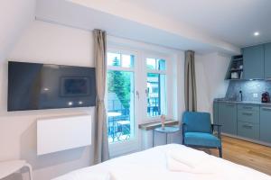 ein Schlafzimmer mit einem Bett und eine Küche mit einem Fenster in der Unterkunft HITrental Riesbach Apartments in Zürich