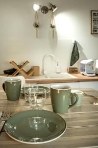 uma mesa com um prato e copos e um lavatório em FLEUR DE VIGNE em Fronsac