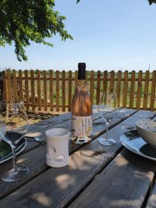 uma garrafa de vinho sentada numa mesa de madeira com copos em FLEUR DE VIGNE em Fronsac