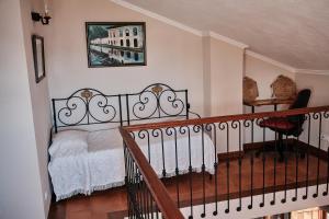 アングラ・ド・エロイーズモにあるCasa da Fajãのベッドルーム1室(錬鉄製のベッド1台、階段付)