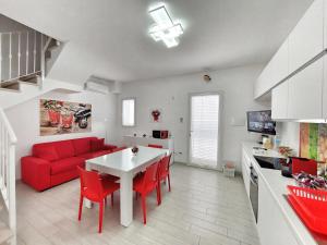 un soggiorno con divano rosso e tavolo di Villa Roberta Spiaggiabianca Deluxe - A 20 metri dal mare a San Pietro in Bevagna