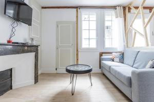 a living room with a couch and a table at Elégant Appartement avec balnéo à 100m du Capitole in Toulouse +9 photos