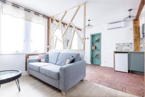 a living room with a couch and a table at Elégant Appartement avec balnéo à 100m du Capitole in Toulouse