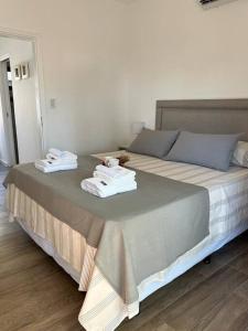 a bedroom with a large bed with towels on it at Superiority 4 in Junín
