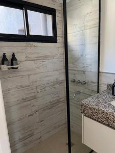 a bathroom with a shower with a stone wall at Superiority 4 in Junín