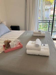 a bed with two towels and two cups and a tray with towels at Superiority 4 in Junín