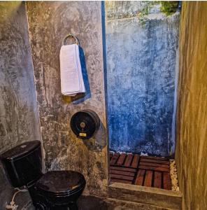 a bathroom with a toilet and a towel on the wall at Urban Hostal Bar in Bucaramanga