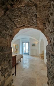 a room with a bed and a stone wall at La Tour de Pezene in Anduze +37 photos