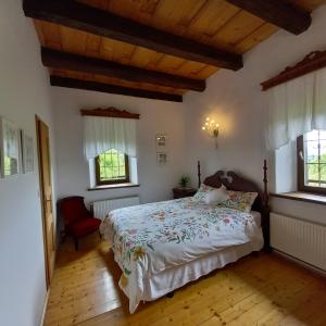 um quarto com uma cama e duas janelas em Country House Zunko em Jelovec