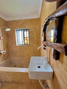 ein Badezimmer mit einem Waschbecken und einer Badewanne in der Unterkunft VICK Boutique Hotel in Banda Kuu