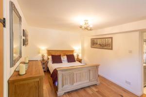 1 dormitorio con 1 cama y escritorio en una habitación en The Old Barn - cottage with spectacular lake view en Port of Menteith