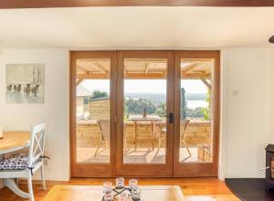 um quarto com uma porta de vidro deslizante e uma mesa em The Old Barn - cottage with spectacular lake view em Port of Menteith