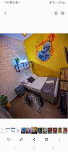 a picture of a bedroom with a bed and a wall at Urban Hostal Bar in Bucaramanga