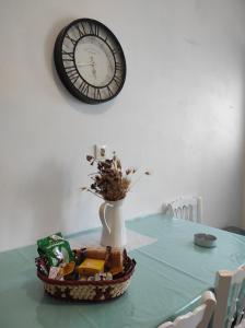 a table with a clock on the wall and a vase at Fabrika Apartment B2 in Vári +11 photos