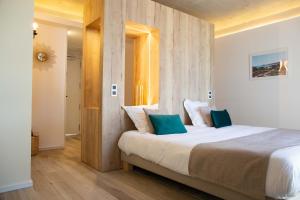 a bedroom with a large bed with blue pillows at Grand Hôtel Du Lido - sur la plage d'Argèles in Argelès-sur-Mer