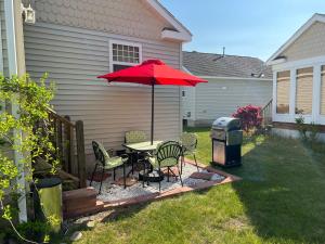 a patio with a table and chairs and an umbrella at Private and Peaceful 2-Bedroom Cottage on Resort close to the beach! in Wells +20 photos
