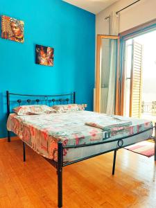 łóżko w pokoju z niebieską ścianą w obiekcie The Charming Abode w mieście Atsipopoulo
