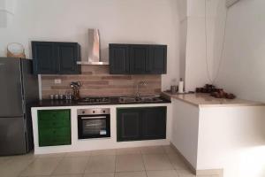 a kitchen with black and green cabinets and a sink at La Stella Marina in Matino +47 photos