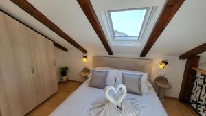 a bedroom with a bed with two hearts on it at Stone House Apartments Didini Dvori Lumbarda in Lumbarda