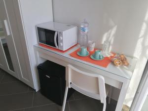 a table with a microwave and cups on it at B&B Villa Agrumé in Messina