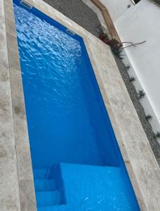 a swimming pool in a house with blue water at Le Clos de l'Olivier in Alès